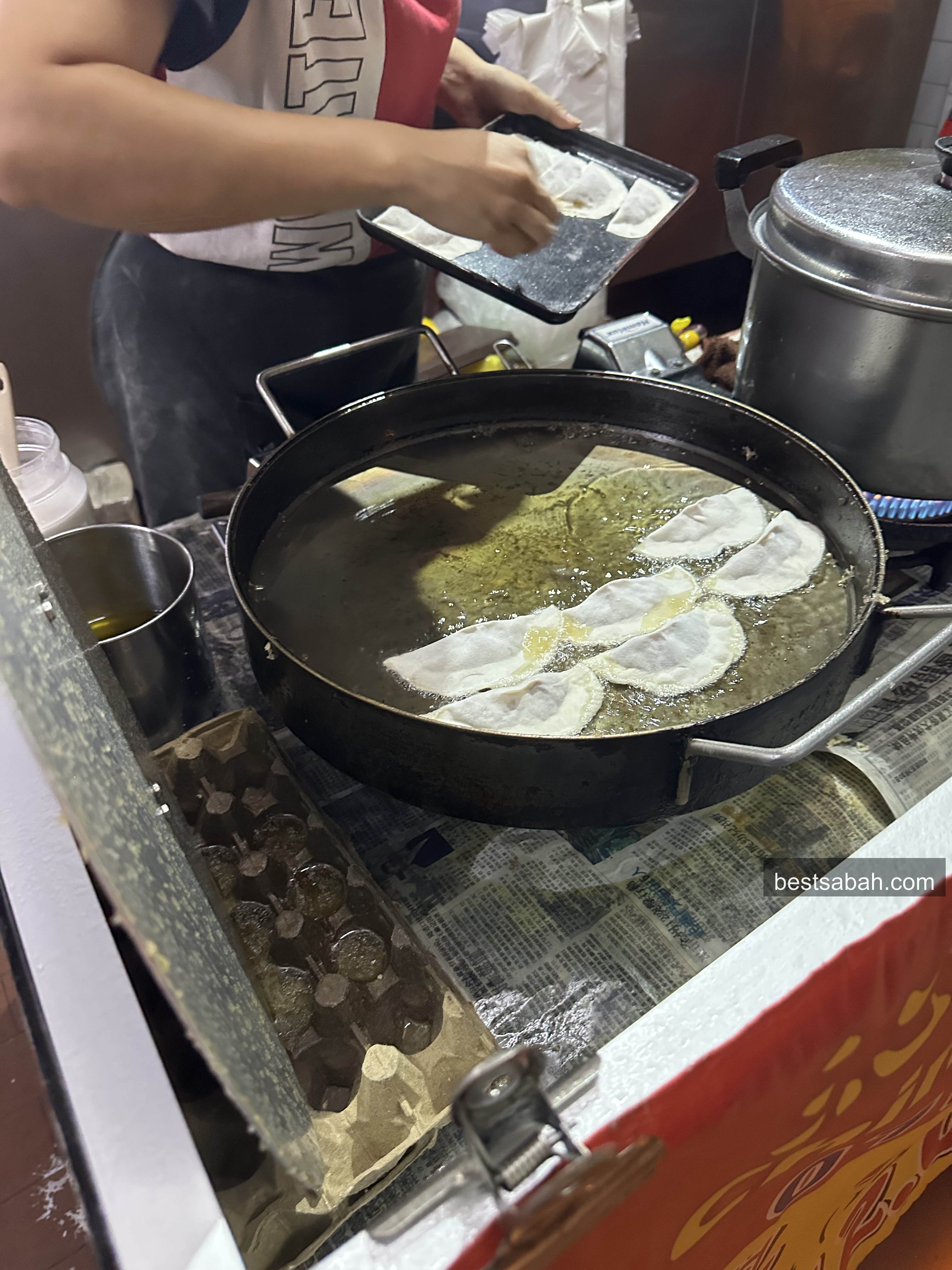 Guo tie frying in a large flat pan of oil at Kai Shun, Foh Sang Kota Kinabalu