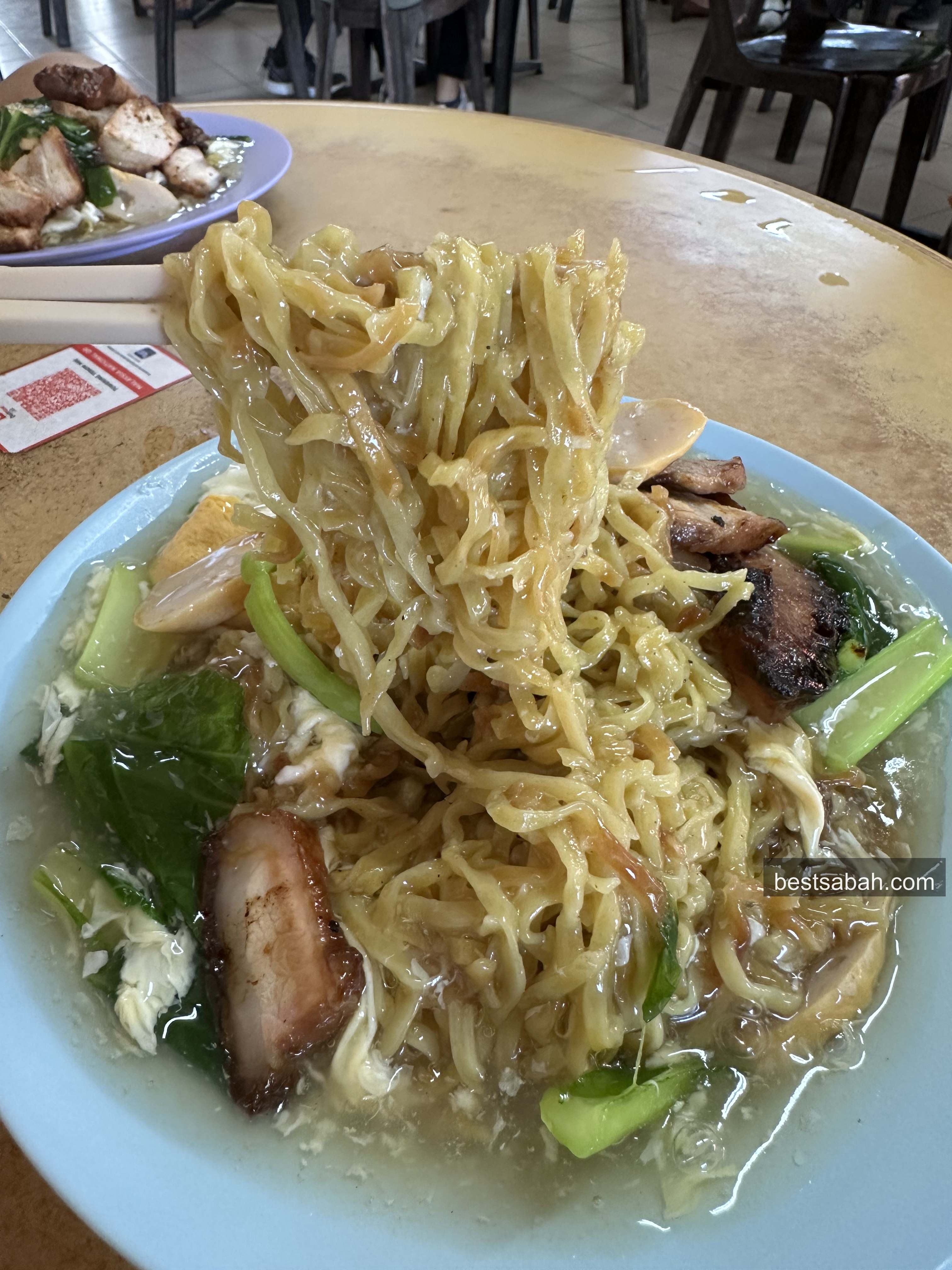Springy tenom mee noodles lifted from the plate at Towering Tenom Mee Kota Kinabalu