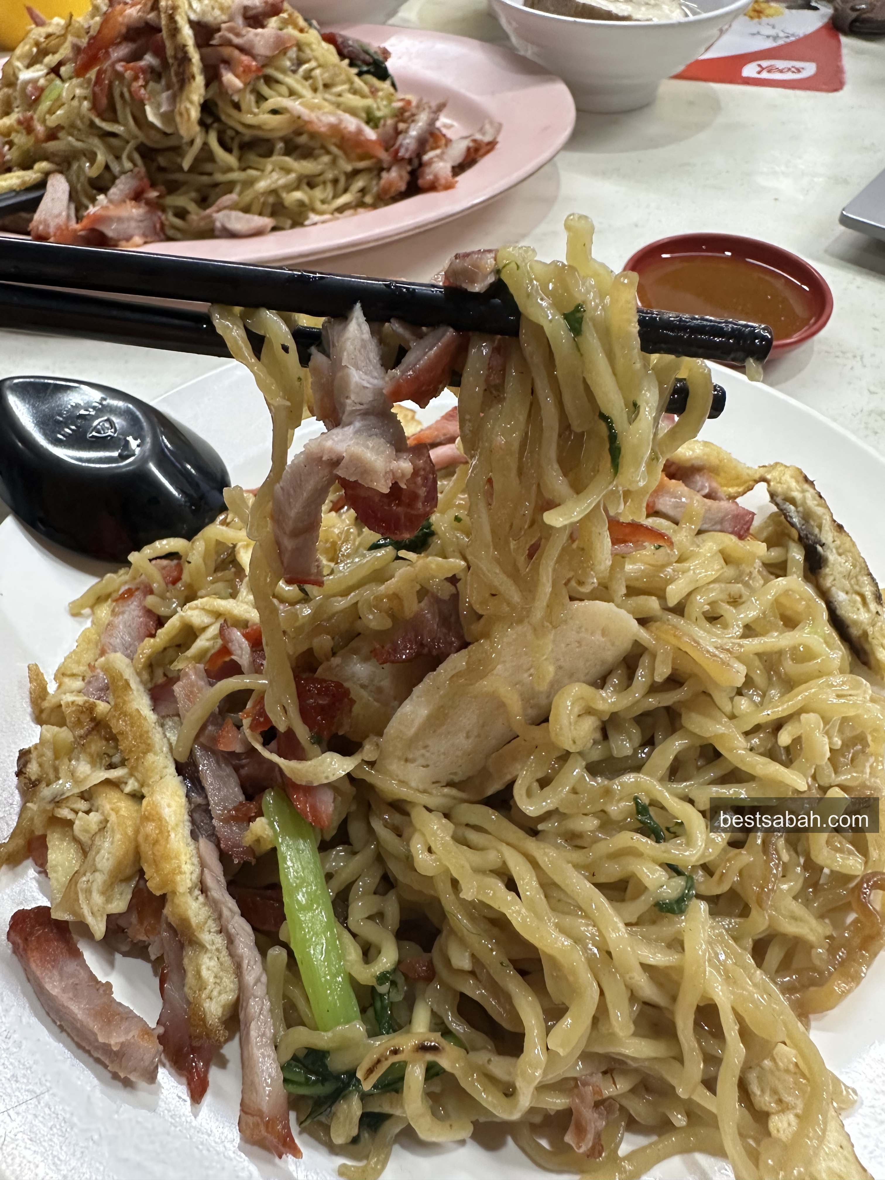 Springy tamparuli mee noodles lifted with chopsticks at Weng Foh Damai Kota Kinabalu