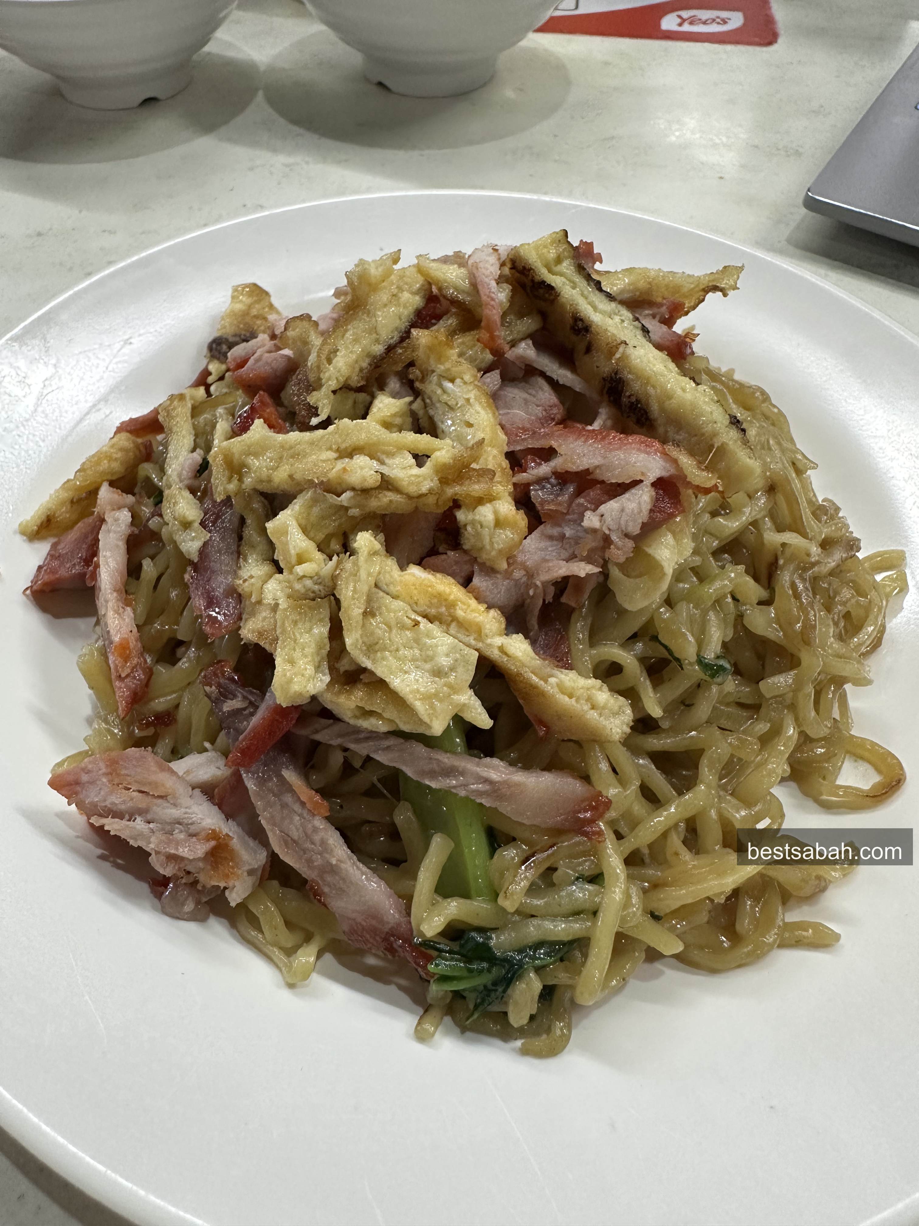 Plate of tamparuli fried noodles with shredded egg, char siew and greens at Weng Foh Kota Kinabalu