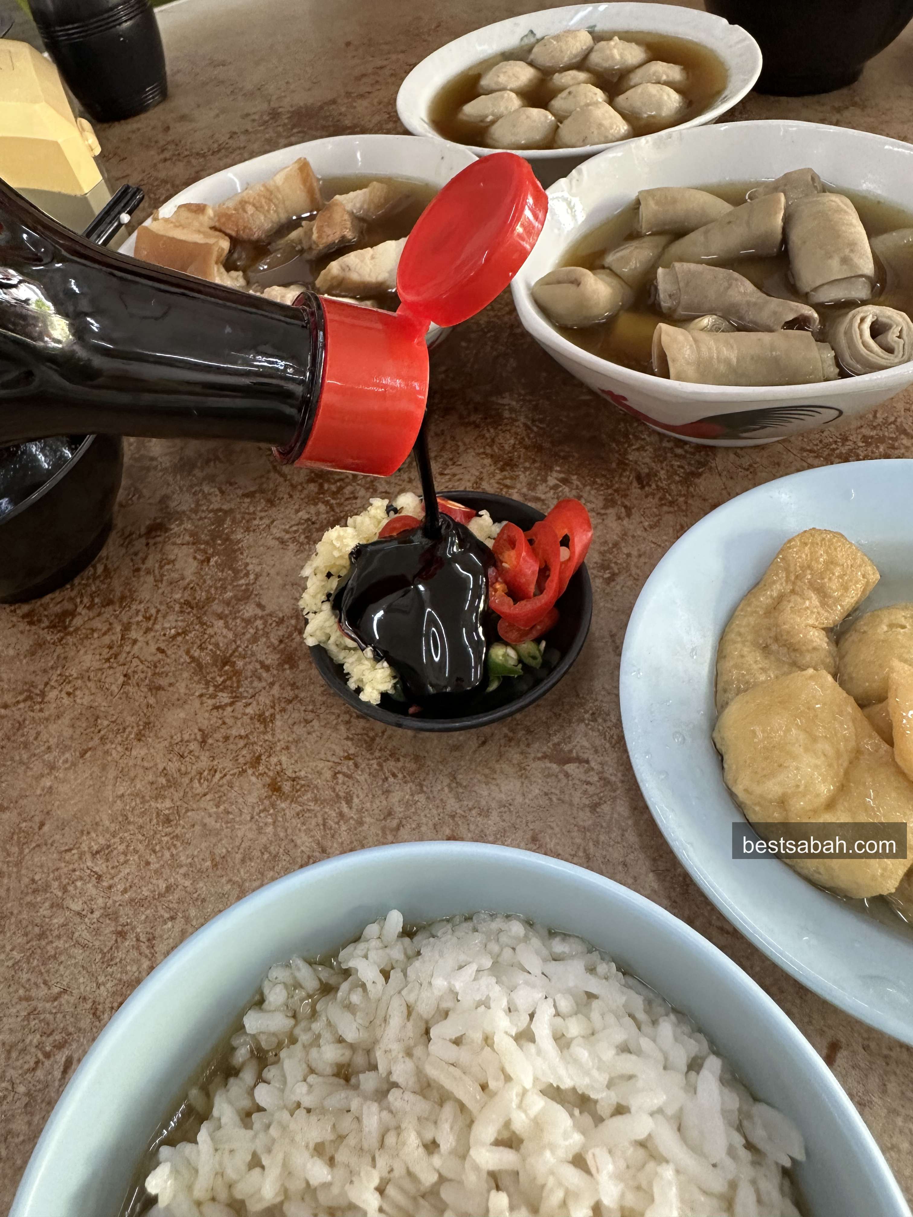 Dipping pork belly into sweet soy sauce at Yu Kee bak kut teh